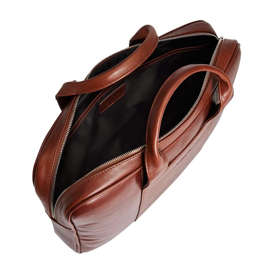 Interior design of the Arsante Briefcase in Whisky Brown, featuring a padded laptop compartment for a 16" Macbook Pro and organized zip pockets.